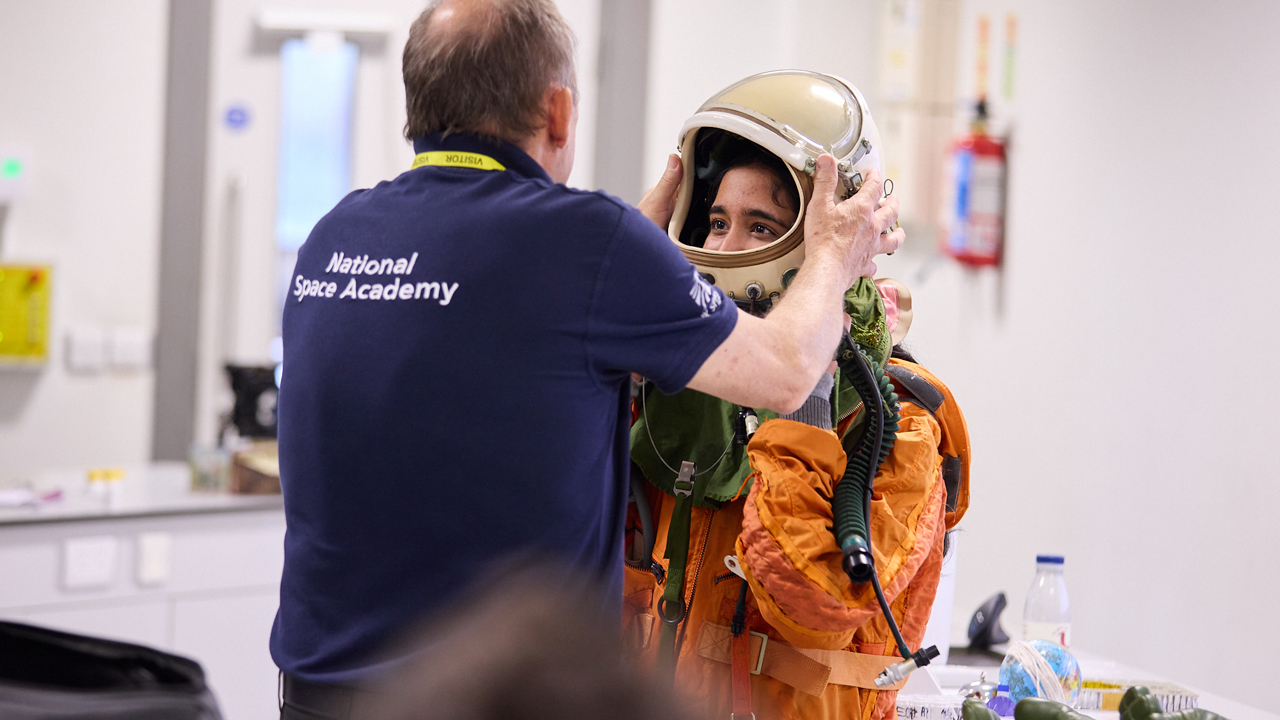 School setting a young person is being dressed in a space suit