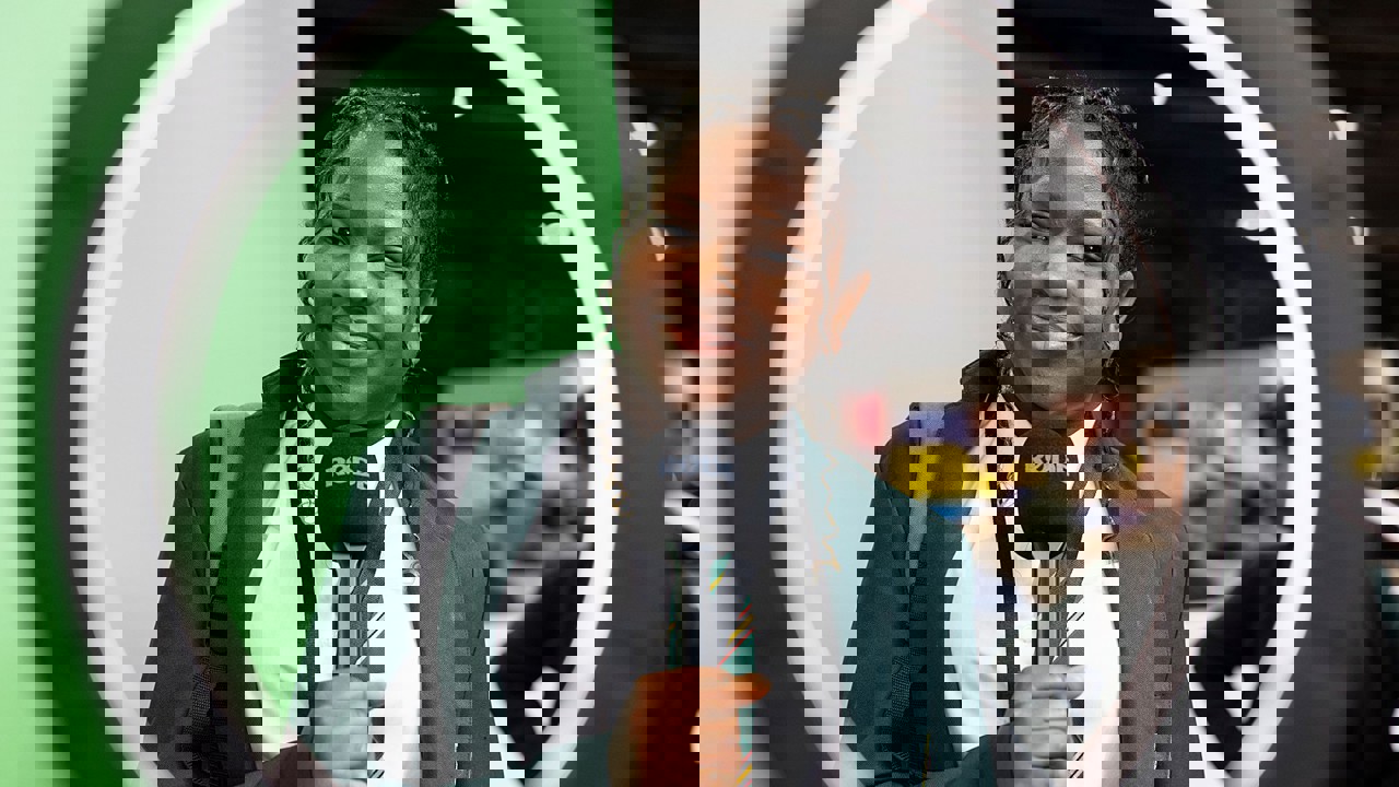 A young person at The Big Bang Fair holds a microphone ad looks through a ring lamp directly into camera