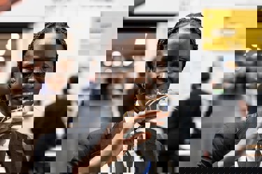 A young person at The Big Bang Fair holds her hand in front of a face as she stares at the stick insect on her fingers.