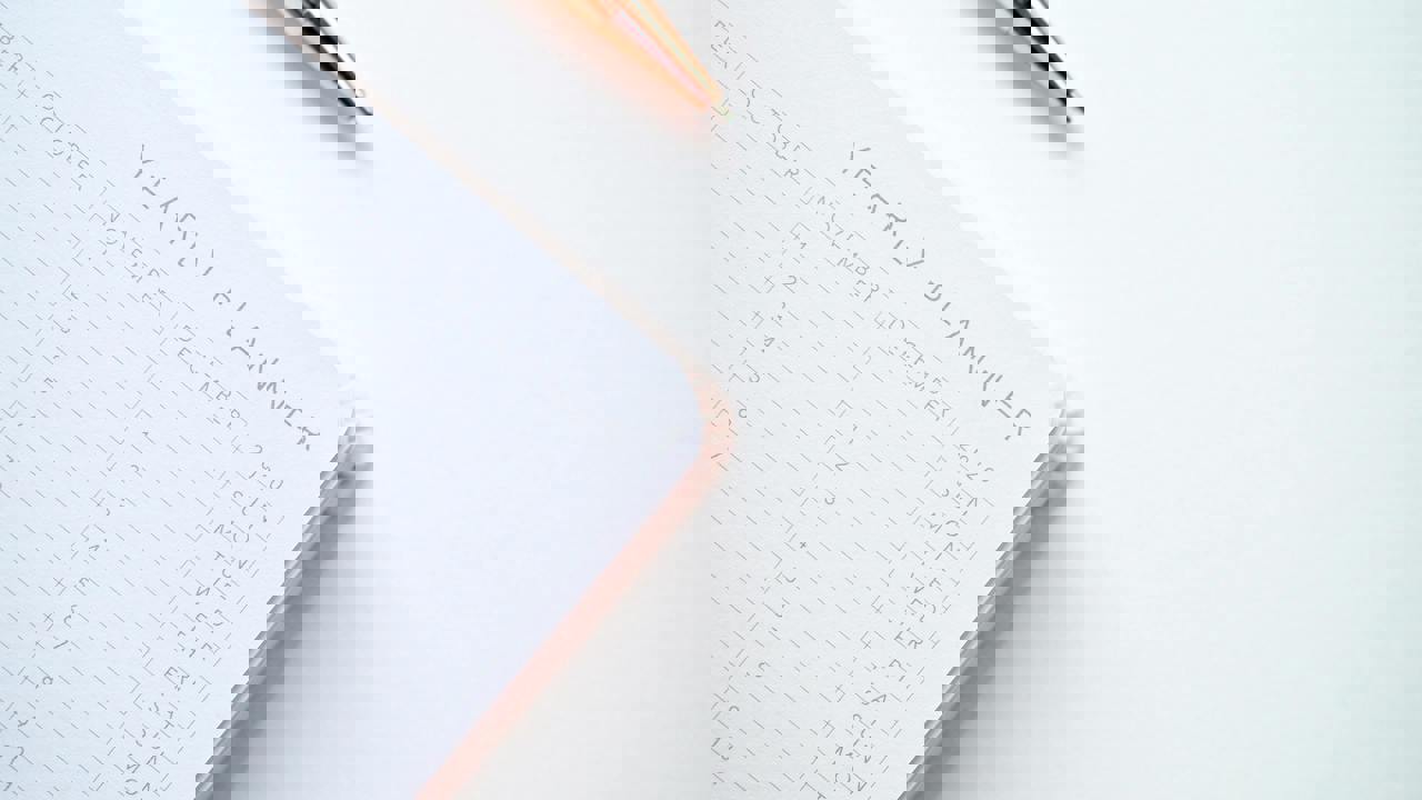 Close up of a corner of an open yearly planner book with pen