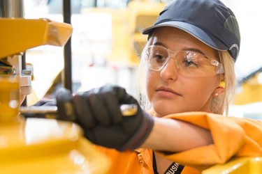 A female engineer working with machinery in protective clothing