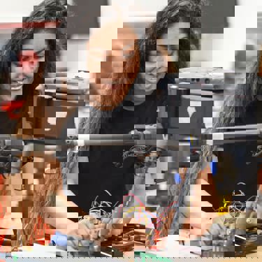 Dilani, a robotics engineer at herotech8, working with tools at a bench