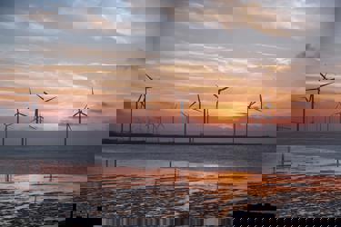 Wind turbines in water at sunset