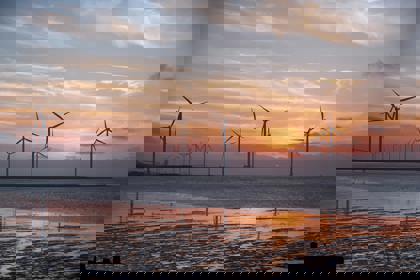 Wind turbines in water at sunset