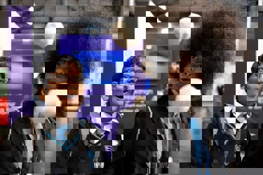 Two young people with expressive faces marvel at a scientific experiment at The Big Bang Fair. In front of them two balls seem to float mid air.