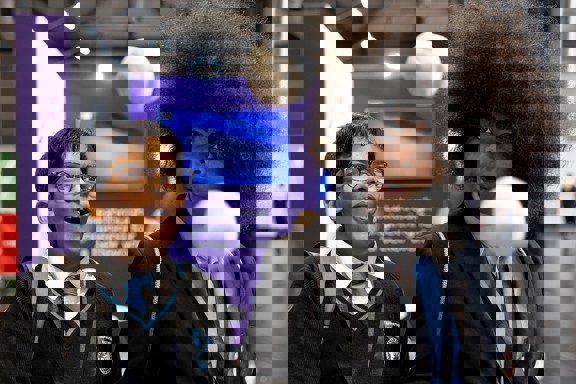 Two young people with expressive faces marvel at a scientific experiment at The Big Bang Fair. In front of them two balls seem to float mid air.