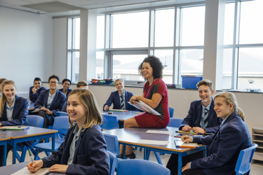 Teacher and students laughing in classroom
